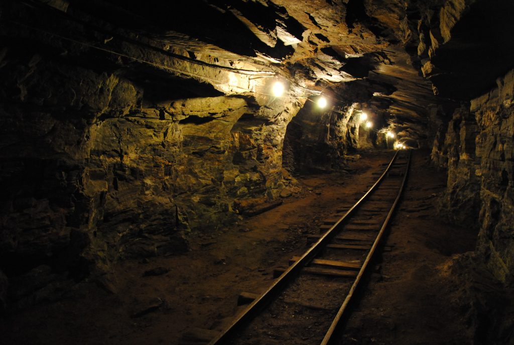 Interior iluminado e com um trilho de uma mina em Ouro Preto