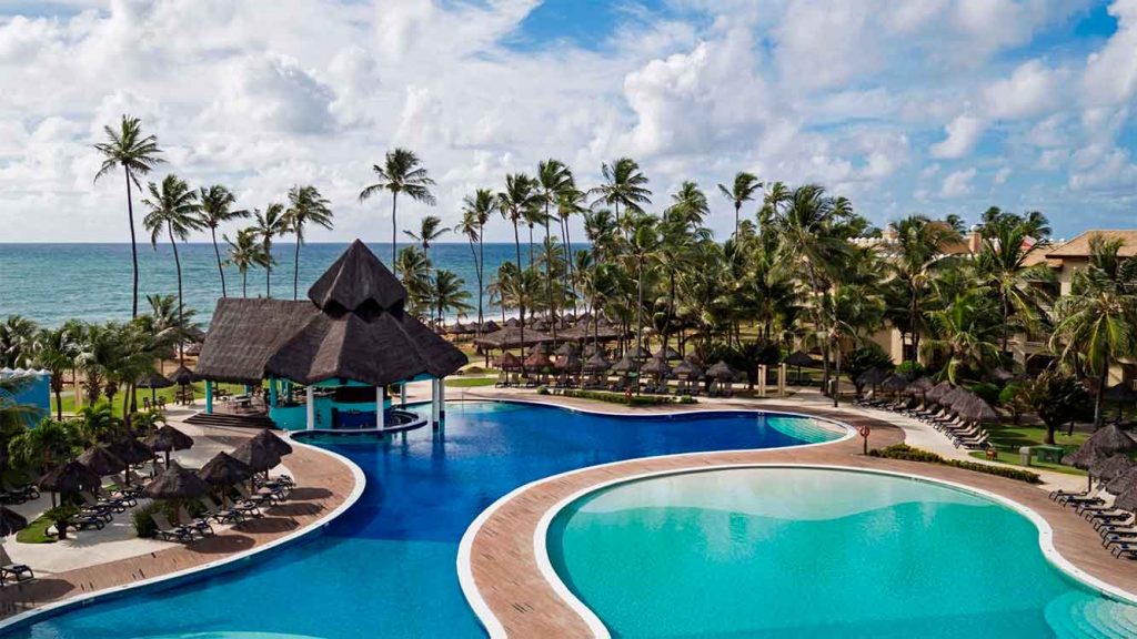 Resorts no Nordeste, um deles, com piscinas diferentes, um bangalô, pequenas cabanas e poltronas para se deitar, cercados por palmeiras 