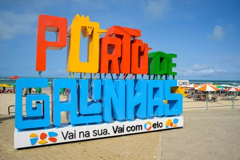 Placa com as palavras 'Porto de Galinhas' colorida na orla da praia de Porto de Galinhas