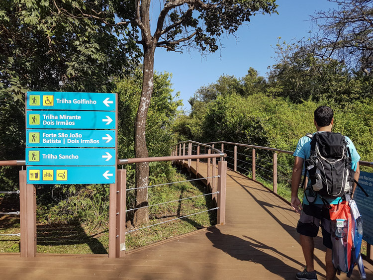 Rapaz caminha para dentro do Parque Nacional de Fernando de Noronha